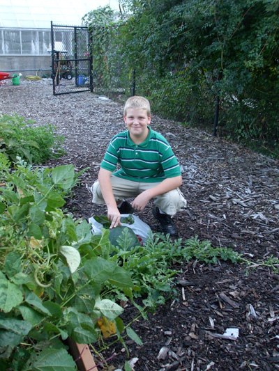 Starting young — Glen Schroering, 11, harvested ‘Moon & Stars,’ an heirloom watermelon at Garfield Park’s Children’s Garden. © Jo Ellen Meyers Sharp 