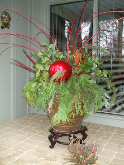 A bright, outdoor ornament is the focal point of this winter arrangement. Split reeds provide the backdrop. (C) Jo Ellen Meyers Sharp