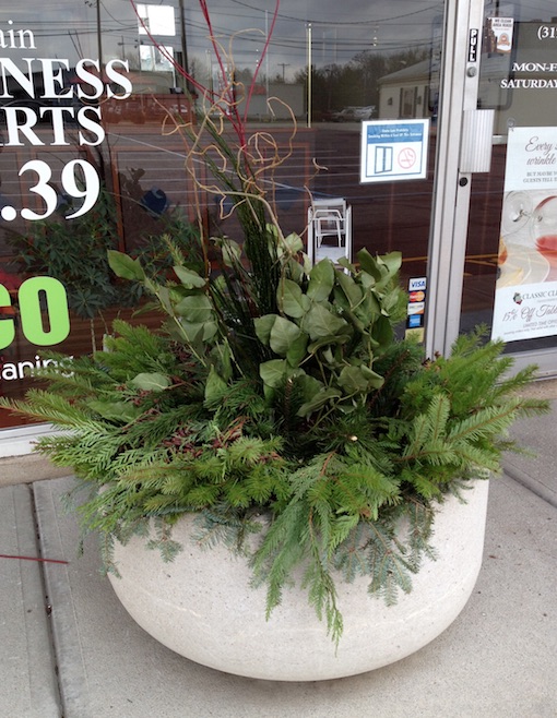 Evergreen boughs and cut stems of curly willow and dogwood provide seasonal fare for a commercial setting. (C) Jo Ellen Meyers Sharp