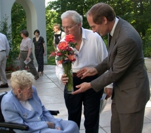 Mark Zelonis (right) presents a vase of flowers to Ruth Lilly at the Indianapolis Museum of Art. The flowers were cut from the gardens at Oldfields, a Lilly family estate on the IMA grounds.(C) Photo courtesy Mark Zelonis